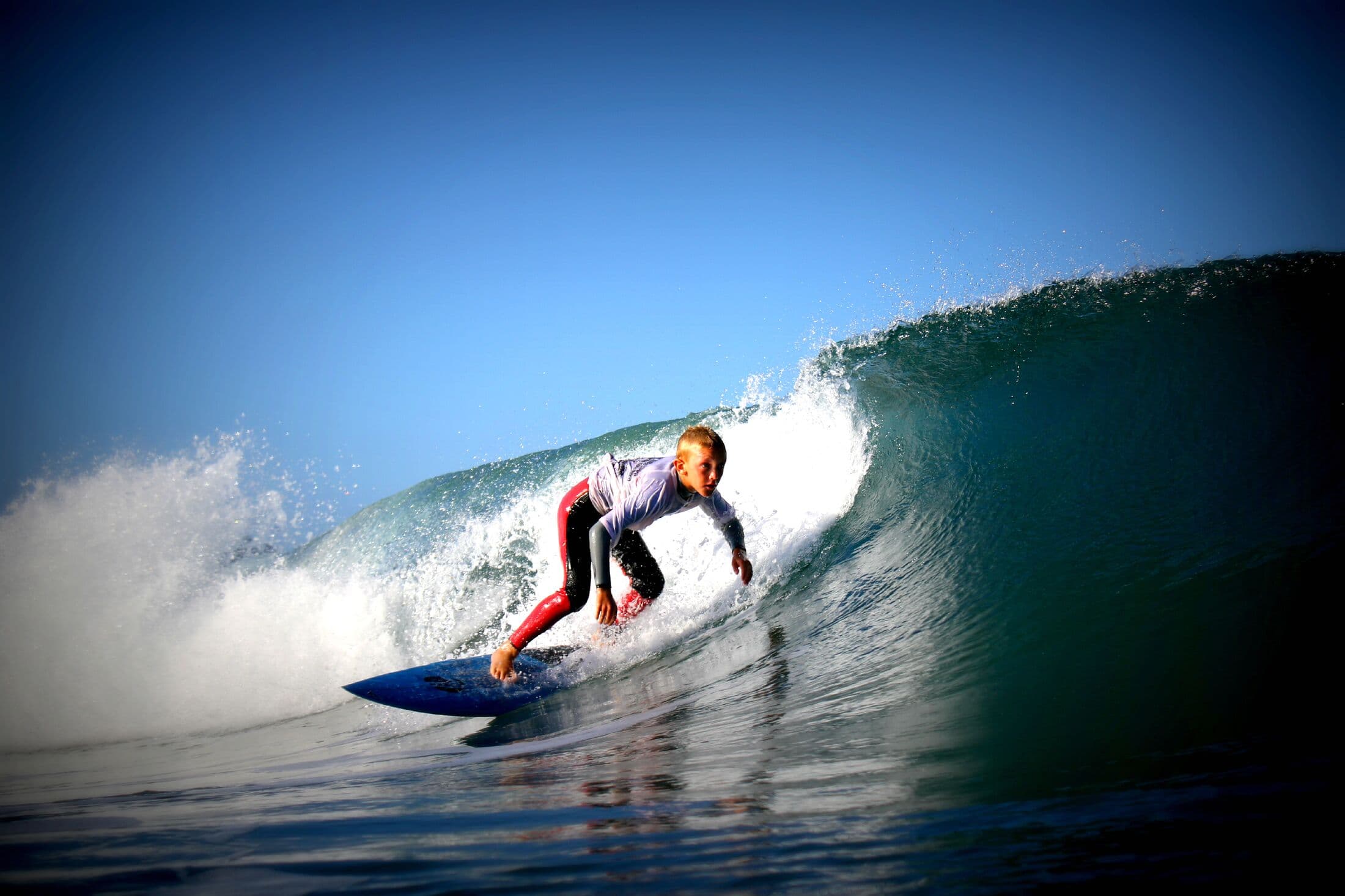 A surfer tucked in a glowing barrel