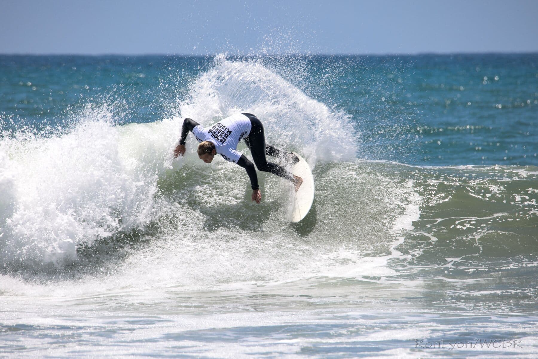 A surfer bursting through whitewater