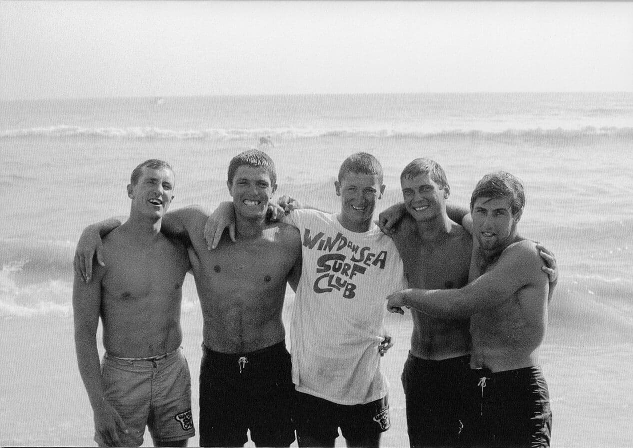 The undefeated WSC paddleboard team in club shirts on the beach